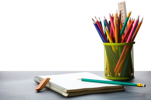 notebook and a container of pencils on the table