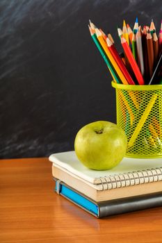 notebook and a container of pencils on the table