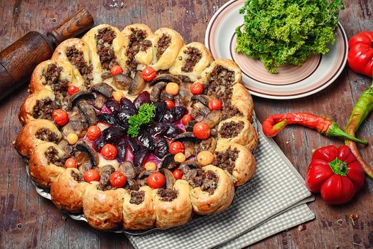 Traditional pie stuffed with meat decorated vegetables