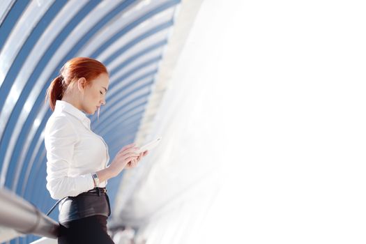 Beautiful modern businesswoman using tablet computer inside modern building