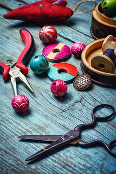 Beads and pliers to assemble the necklace on blue background