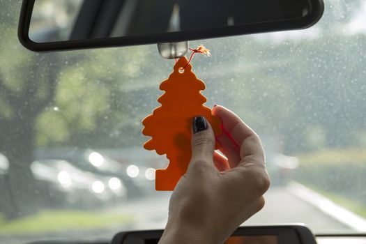 Arm girls with trendy manicure keeps air freshener in your car.