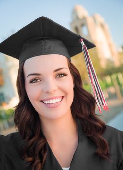 Happy Graduating Mixed Race Woman In Black Cap and Gown Celebrating on Campus.