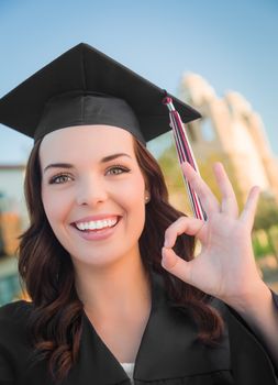 Happy Graduating Mixed Race Woman In Black Cap and Gown Celebrating on Campus.