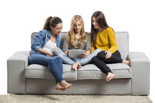 Girls sitting in the couch watching something on a tablet