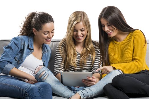 Girls sitting in the couch watching something on a tablet