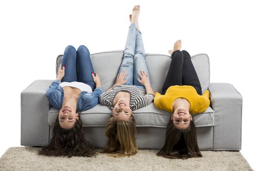 Happy teen girls at home sitting on the couch