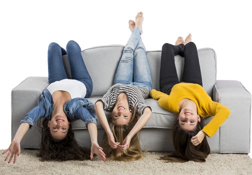 Happy teen girls at home sitting on the couch