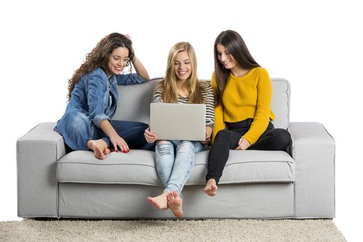 Happy teen girls at home with a laptop