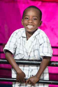 This child behind iron bars shows his joy laughing.