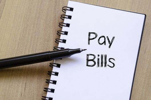 Pay bills text concept write on notebook with pen