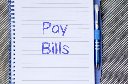 Pay bills text concept write on notebook with pen