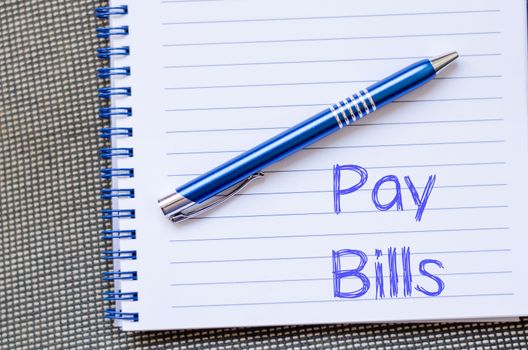 Pay bills text concept write on notebook with pen