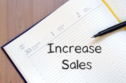 Increase sales text concept write on notebook with pen