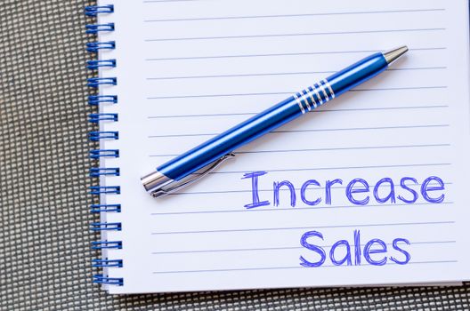 Increase sales text concept write on notebook with pen