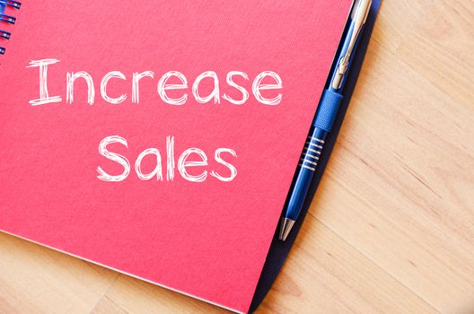 Increase sales text concept write on notebook with pen