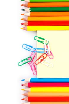 set of colored pencils and paper clips on a white background