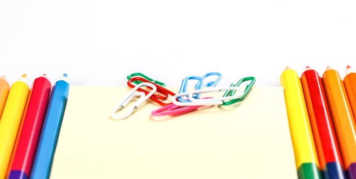 set of colored pencils and paper clips on a white background