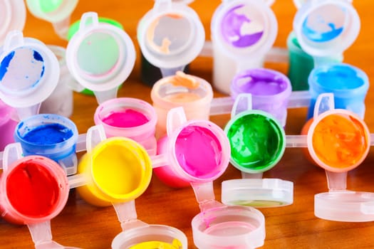 set of colorful paints close-up on wooden background