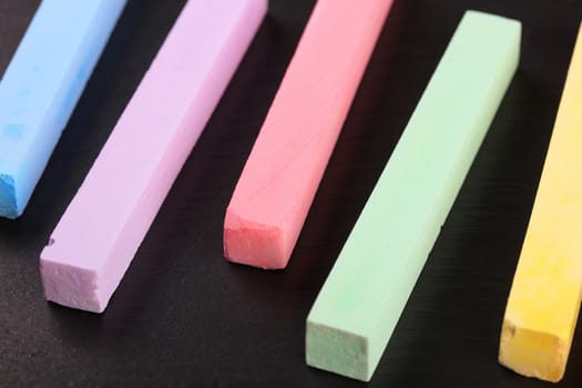 set of colored crayons on a black background