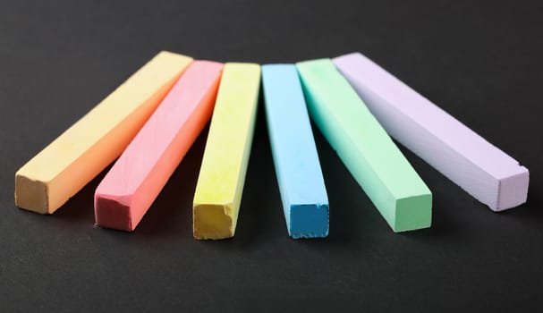 set of colored crayons on a black background