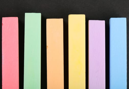 set of colored crayons on a black background