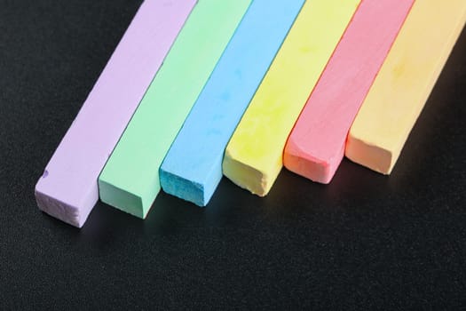 set of colored crayons on a black background