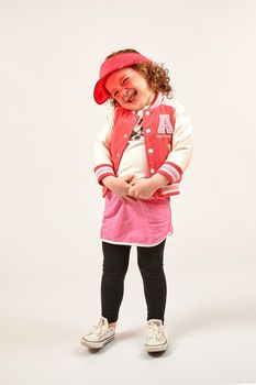 Little girl with red cap standing and smiling