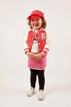 Little girl with red cap standing and smiling