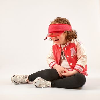 Little girl with red cap standing and smiling