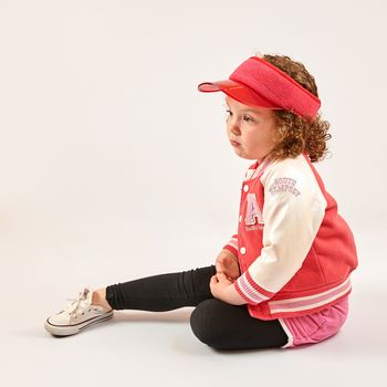 Little girl with red cap standing and smiling