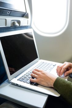 Woman using laptop on airplane