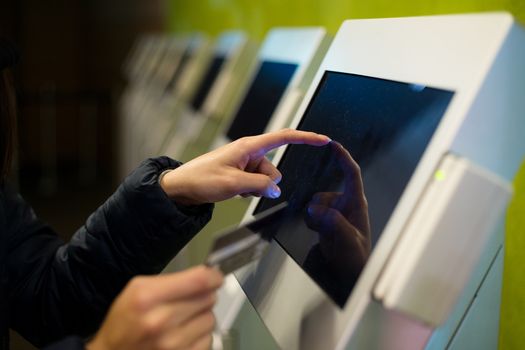 Woman touch on screen of automatic ticketing system