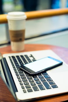 Cellphone and laptop computer in cafe shop