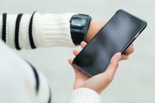 Woman connecting with cellphone and smartwatch