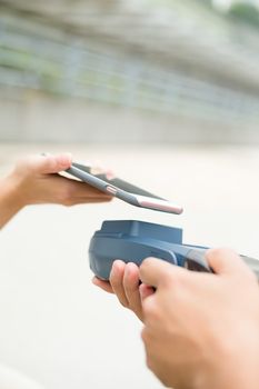 Customer using mobile phone on pos machine