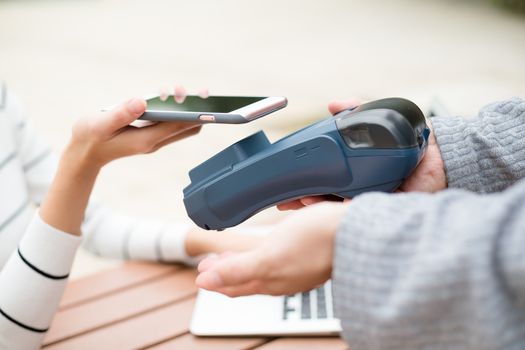 Woman using mobile phone to pay