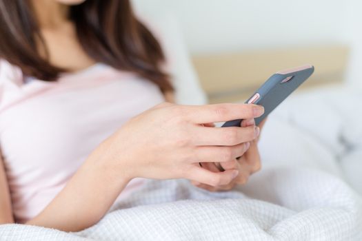 Women are playing a smart phone in bed