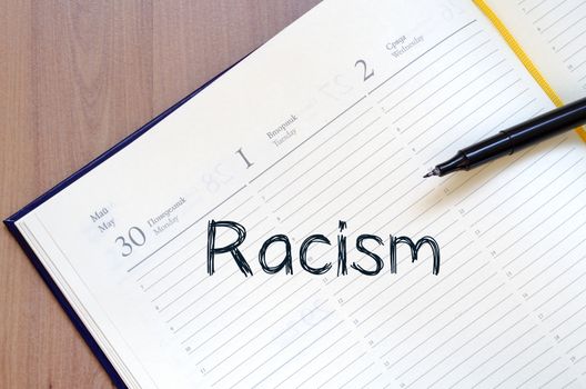 Racism text concept write on notebook with pen
