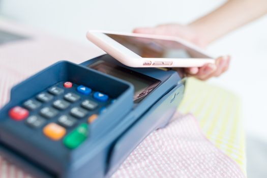 Woman paying with NFC technology on smart phone