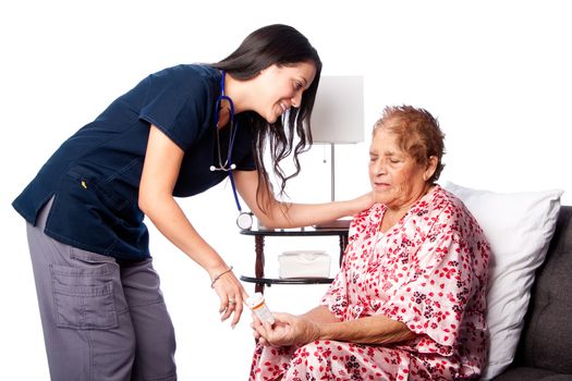 Nurse explaining prescription medication to senior patient, home medical health concept.