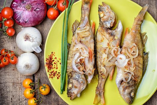 Dish of fried perch and vegetables on rustic recipe