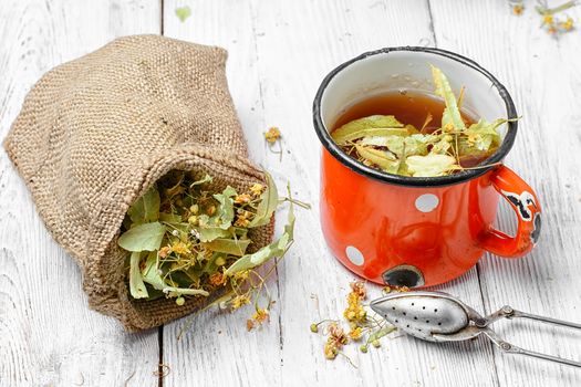 Iron mug of tea brewed with dried medicinal inflorescence of Linden