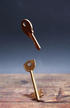 Door key standing on wooden board against dark background