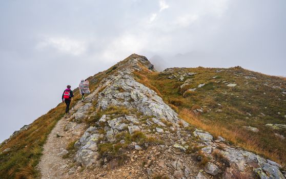 Hiking Trail with Tourists on the Hill in the Mountains in the Mist