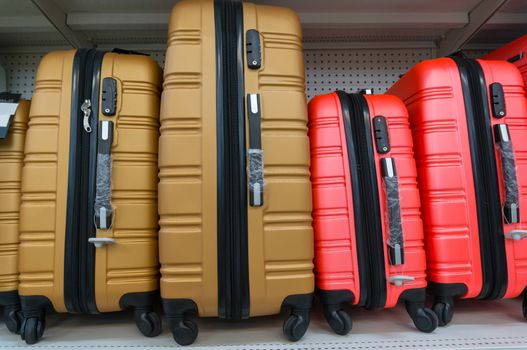 Yellow and Red suitcases in a row on shelf