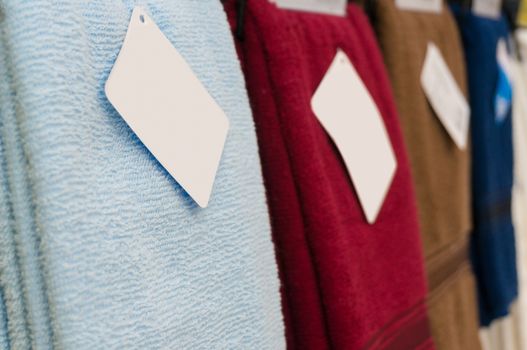 Colorful towels on supermarket shelves with Blank Tags, Shallow Depth of Field