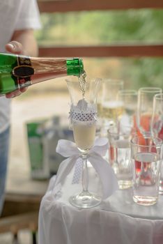 the waiter pours champagne into glasses