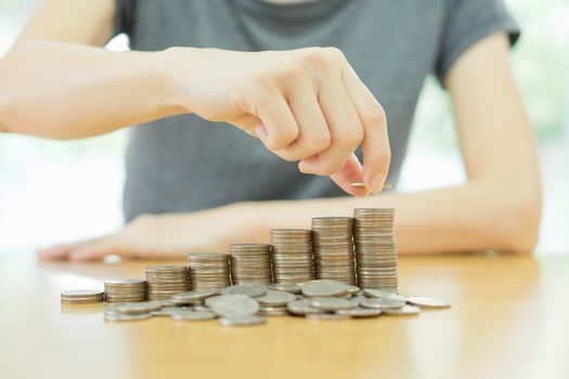 woman put coins to stack of coins