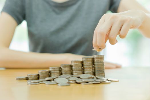 Hand put coins to stack of coins